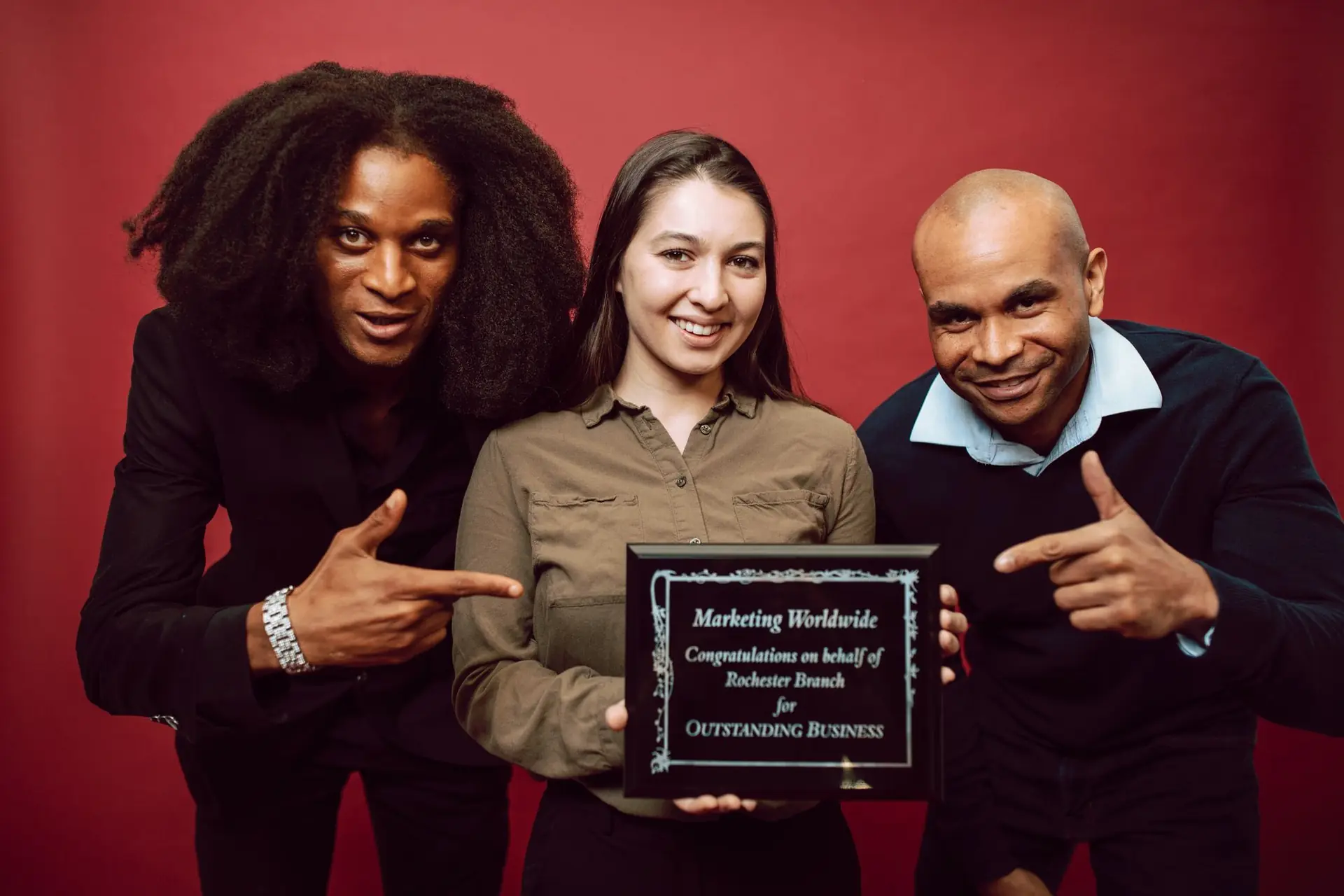 Team posing with a recognition plaque